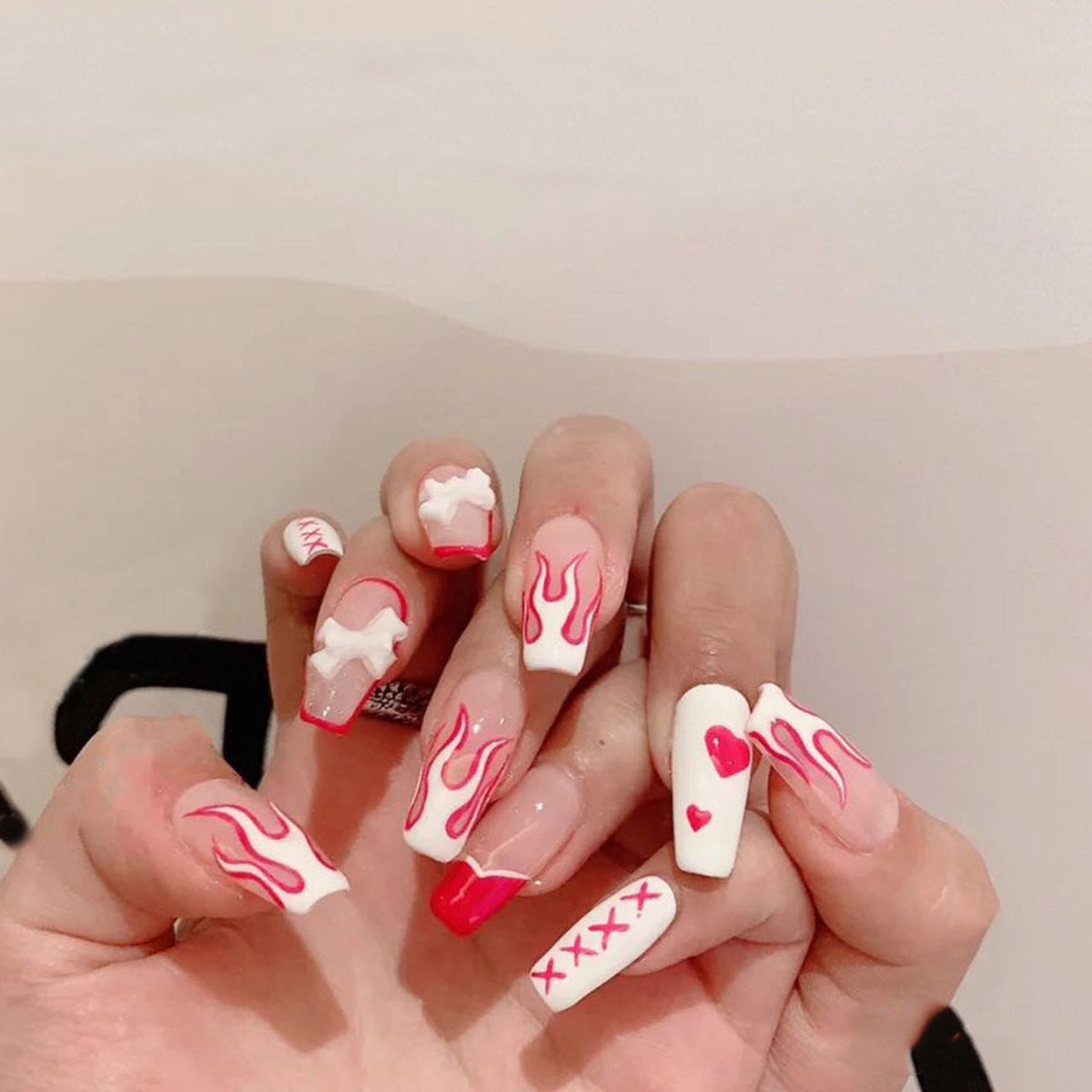Removable Flame Bow nail patch from Everyday Needs and Wants with fiery flame and bow design on a clear background.