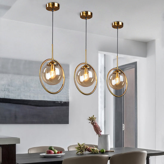 Nordic modern minimalist glass pendant light with clear spherical shade hanging from a sleek metal fixture